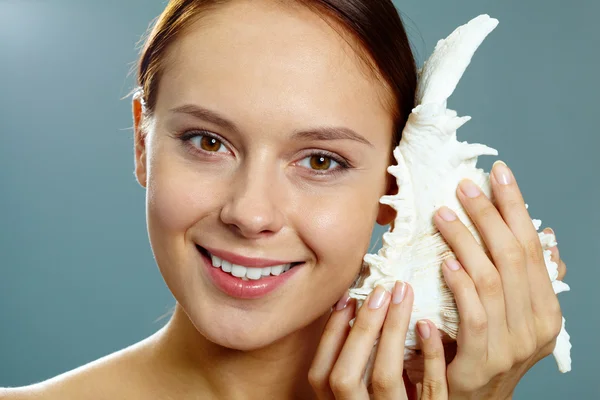 Chica sosteniendo cáscara por oreja — Foto de Stock