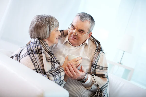 Senior koppel verpakt in plaid — Stockfoto