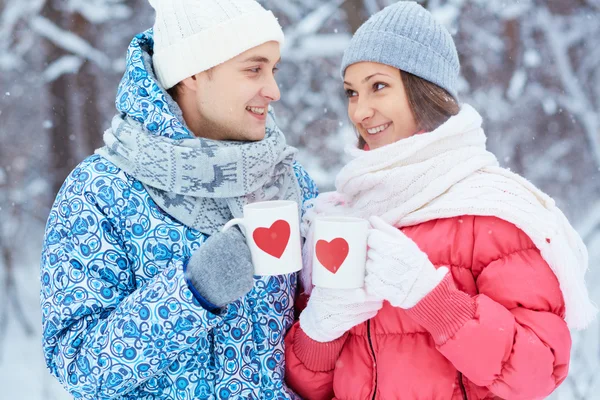 Pareja joven sosteniendo copas — Foto de Stock