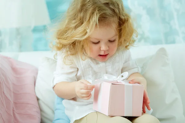 Girl unwrapping present — Stock Photo, Image