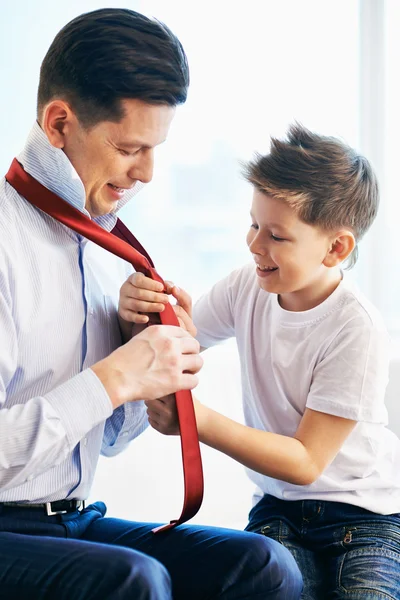 Boy kijken naar zijn vader gelijkmakende stropdas — Stockfoto