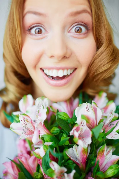 Menina surpresa com lírios rosa — Fotografia de Stock