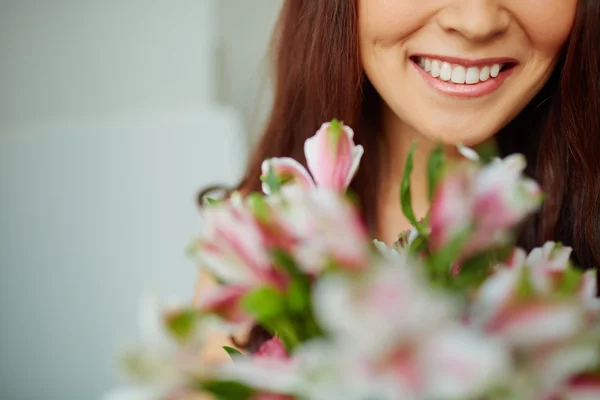 Toothy leende och blommor — Stockfoto