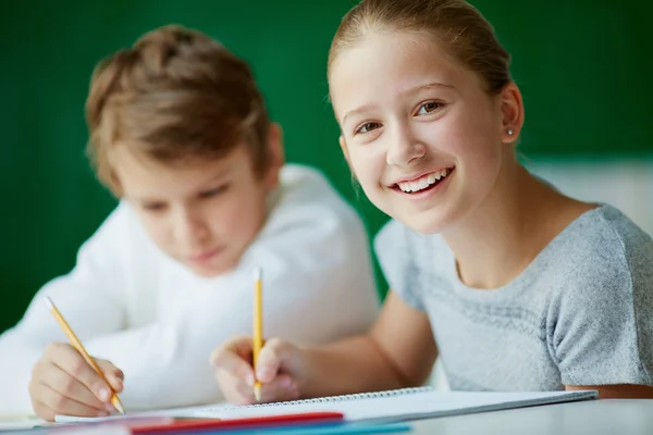 Studentessa disegno con il suo compagno di classe — Foto Stock