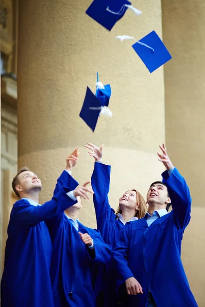 Estudiantes lanzando sus sombreros —  Fotos de Stock