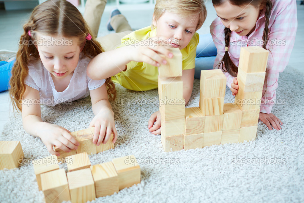 Friends playing with wooden bricks
