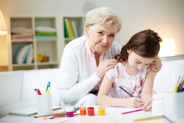 Tjej att göra kort med mormor — Stockfoto