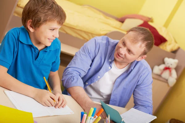 Pai com filho fazendo trabalhos escolares — Fotografia de Stock