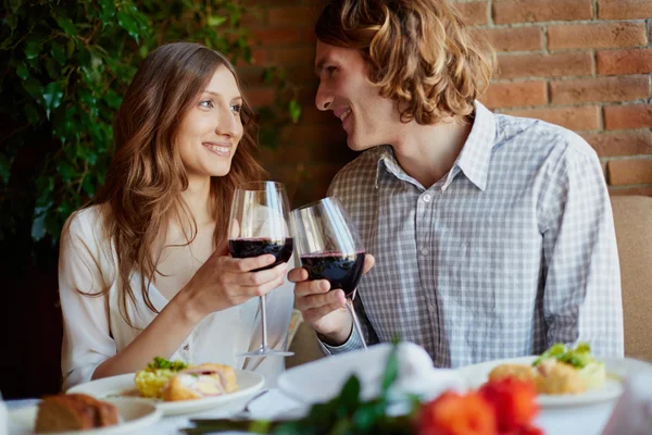 Paar stößt mit Rotwein an — Stockfoto