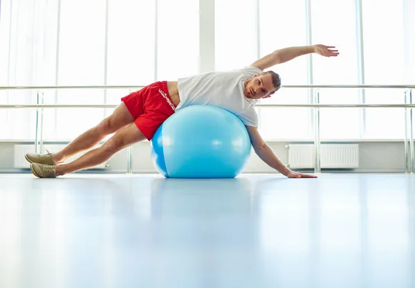 Bărbatul face exerciții fizice pe minge — Fotografie, imagine de stoc