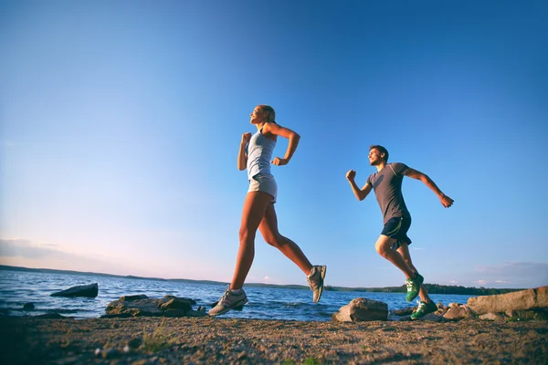 Couple running on the coastline — Stock Photo, Image