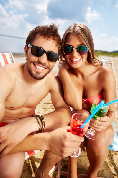 Amantes con bebidas teniendo fiesta en la playa — Foto de Stock