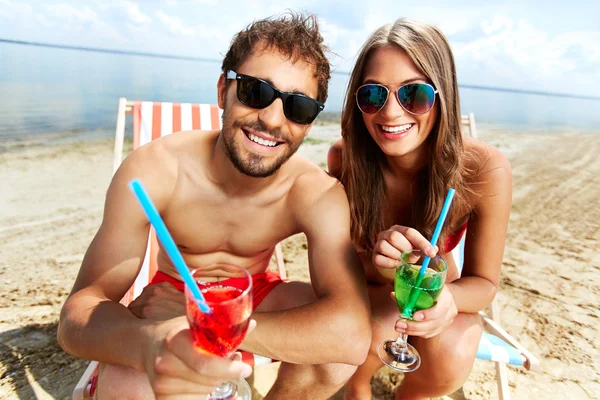 Amantes com bebidas que fazem festa na praia — Fotografia de Stock