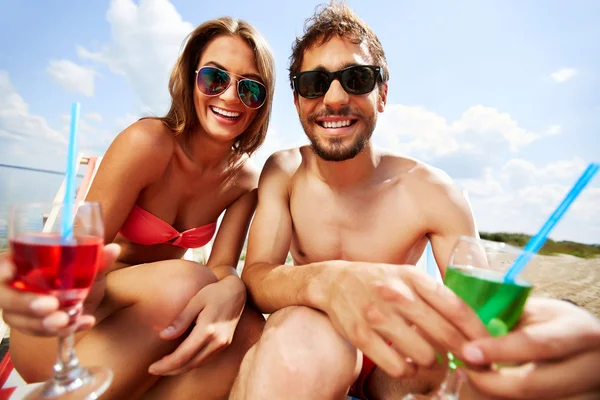 Gli amanti con bevande avendo festa in spiaggia — Foto Stock