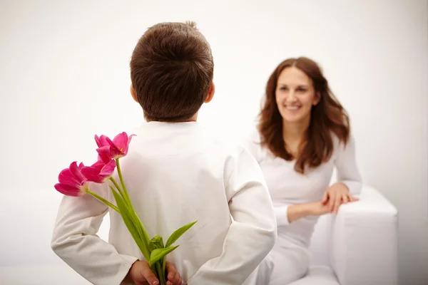 Muchacho con un montón de tulipanes para su madre — Foto de Stock