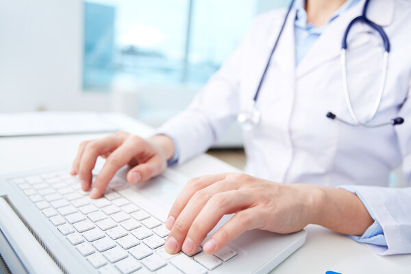 Medical worker typing on laptop