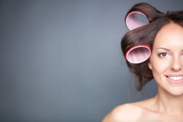 Vrouw met haar krulspelden — Stockfoto