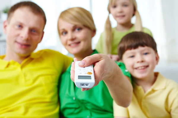 Mando a distancia en mano femenina — Foto de Stock