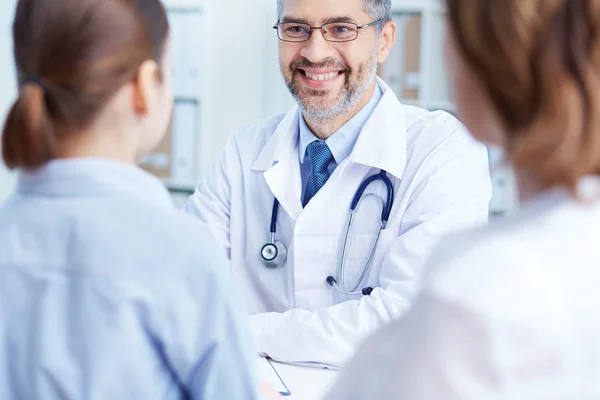 Practitioner speaking to patients — Stock Photo, Image