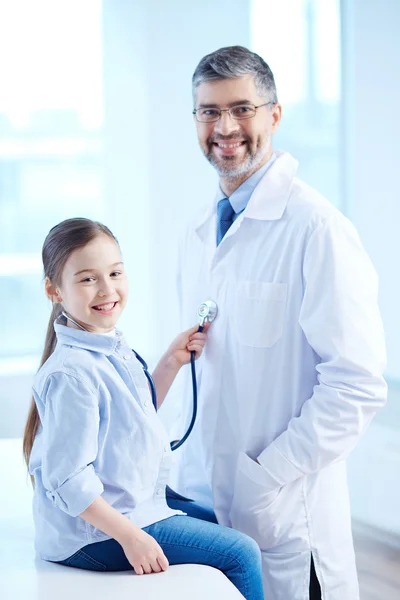Девушка осматривает врача стетоскопом — стоковое фото