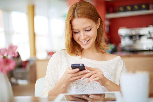 Woman reading sms  in cafe