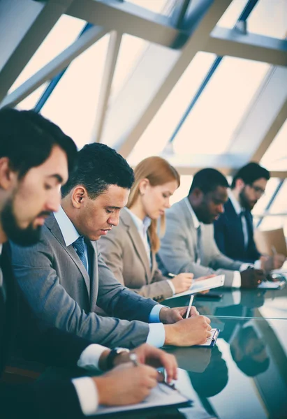 Affärsman att göra anteckningar på seminarium — Stockfoto