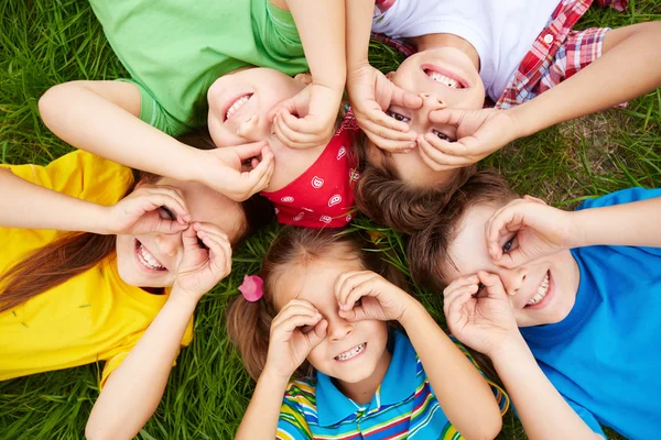 Niños acostados en la hierba — Foto de Stock