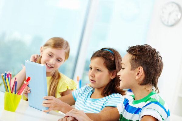 Classmates using digital tablet