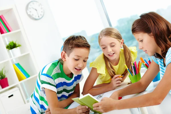 Compagni di classe guardando la nota nel quaderno — Foto Stock