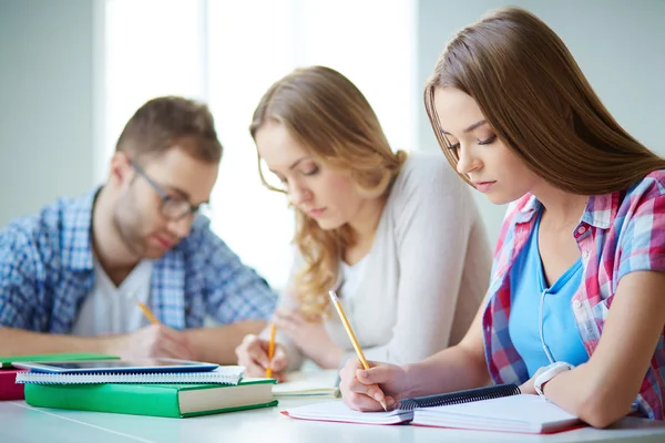 Gruppenmitglieder erledigen schriftliche Aufgabe — Stockfoto