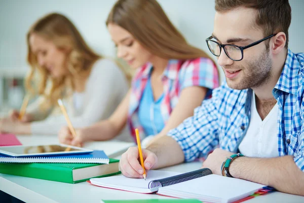 Groupmates skriftlig uppgift på lektion — Stockfoto