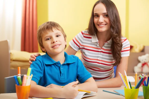 Écolier et mère faisant des travaux scolaires — Photo