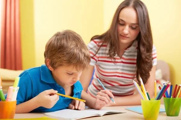 Schüler und Mutter machen Hausaufgaben — Stockfoto