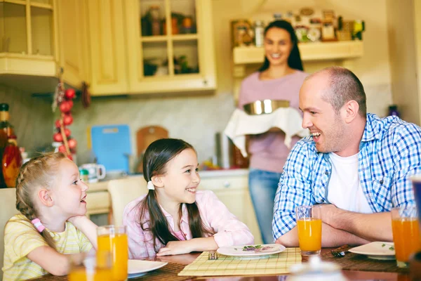 Девушки разговаривают с отцом на кухне — стоковое фото