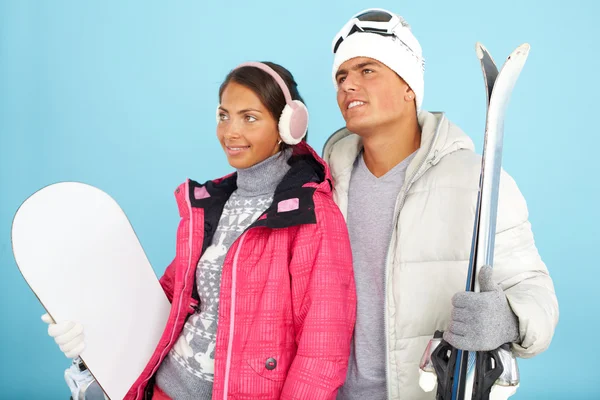 Dziewczyna i człowiek posiadający snowboard i narty — Zdjęcie stockowe