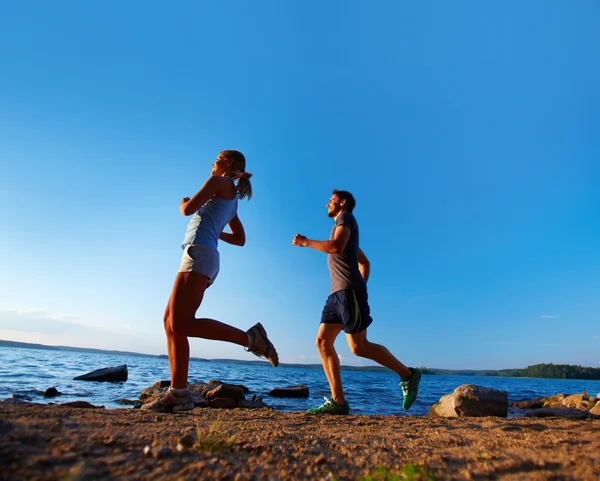 Couple running on the coastline — Stock Photo, Image