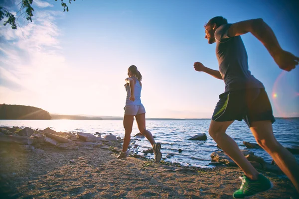 Couple running on the coastline — Stock Photo, Image