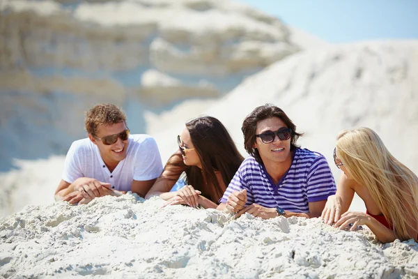 Vrienden rusten op het zand — Stockfoto