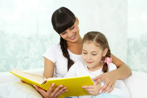 Menina e sua mãe lendo livro — Fotografia de Stock