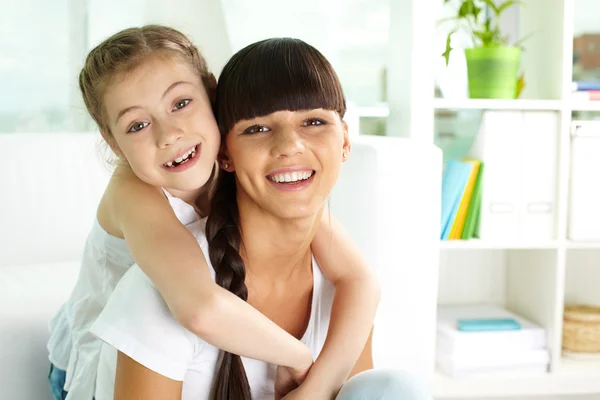 Chica sonriente y su madre — Foto de Stock