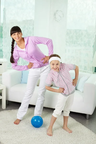 Menina e mãe fazendo exercício físico — Fotografia de Stock