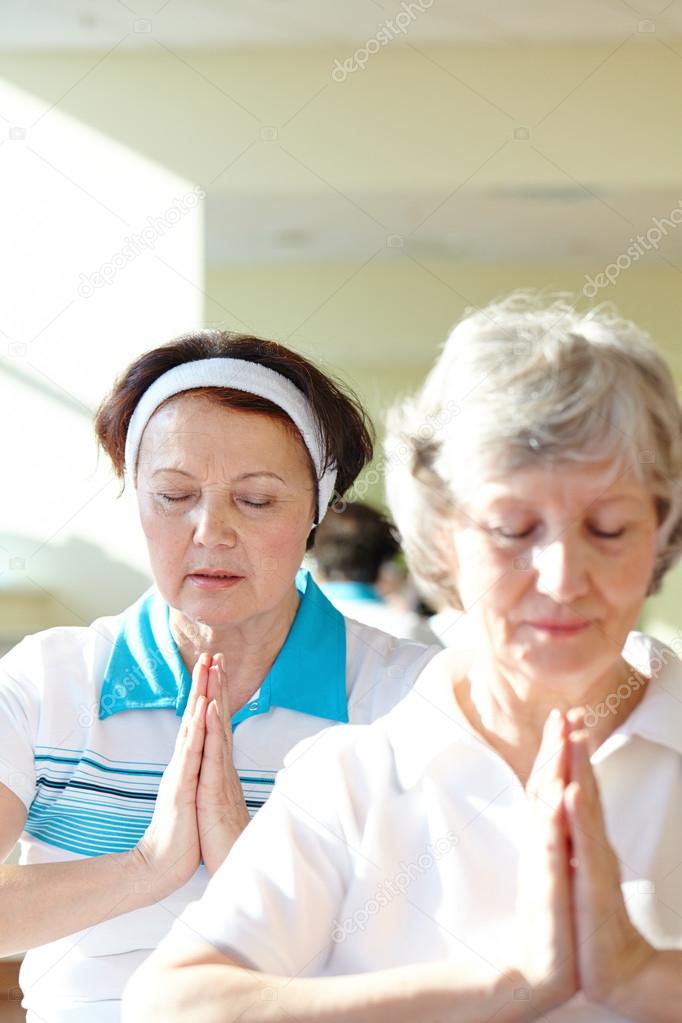 Aged women doing yoga exercise