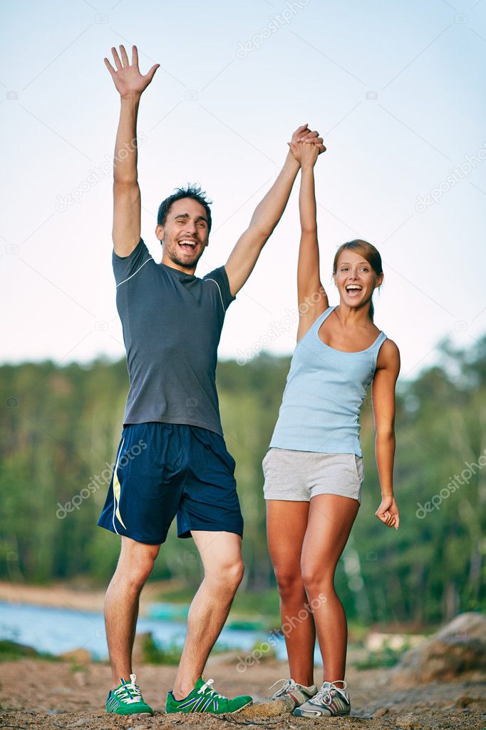 Happy couple raising arms