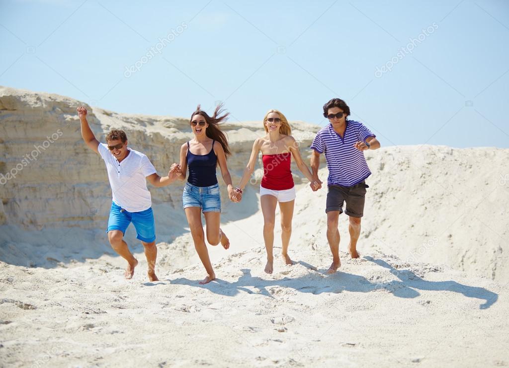 Young people running on the sand