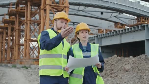 Sledování Záběru Mužských Ženských Inženýrů Záchranné Vestě Tvrdých Čepicích Diskutující — Stock video