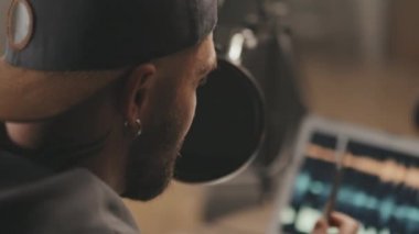 Podcast sırasında mikrofona konuşan sakallı genç adamın yavaş çekimini kapat