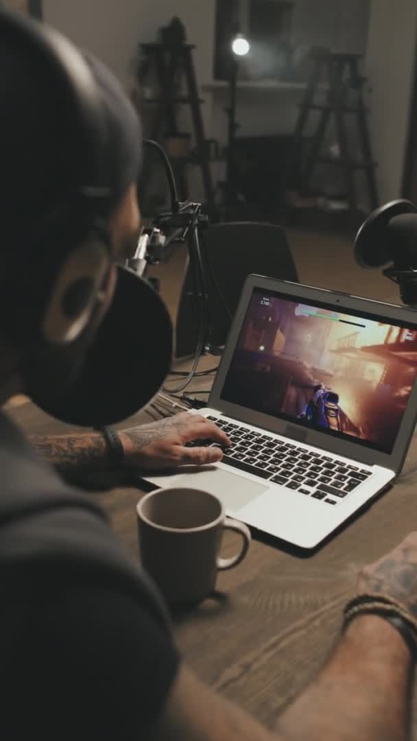 Портативный Вертикальный Снимок Человека Наушниках Сидящего Столом Играющего Видеоигры Ноутбуке — стоковое видео