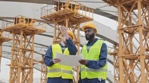 Inyección Mediana Bajo Ángulo Ingenieros Caucásicos Afroamericanos Chalecos Seguridad Sombreros — Vídeo de stock