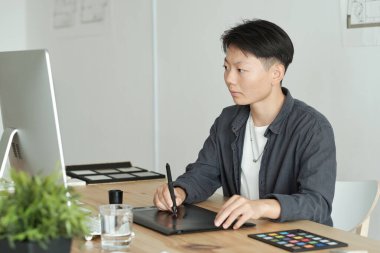 Genç modern grafik tasarımcısı bir şeyler çiziyor.