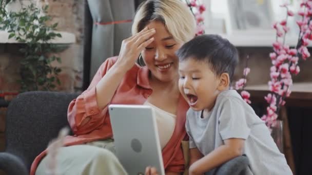 Genç Asyalı Kadın Yaşındaki Oğlunun Komik Videolar Izleyerek Dijital Tabletle — Stok video